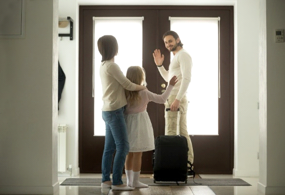 Smiling father waving goodbye to his daughter while leaving with a suitcase in Henderson, NV