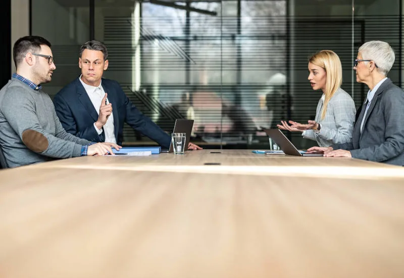 contested divorce concept with lawyers and clients arguing at conference table